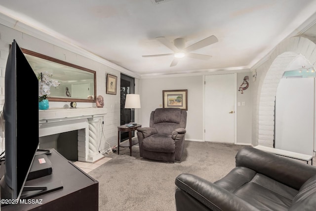 8360 E Mary Dr, Tucson, AZ 85730 - carpeted living area with a ceiling fan, ornamental molding, arched walkways, and a fireplace with flush hearth