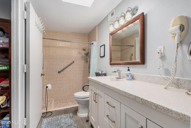 8360 E Mary Dr, Tucson, AZ 85730 - bathroom with tiled shower, toilet, vanity, and wood finished floors