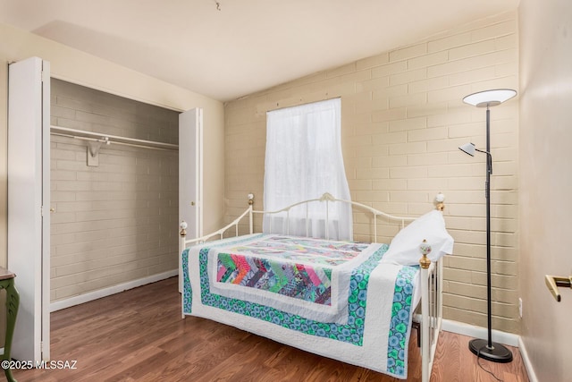 8360 E Mary Dr, Tucson, AZ 85730 - bedroom with wood finished floors, baseboards, brick wall, and a closet