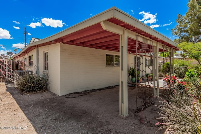 8360 E Mary Dr, Tucson, AZ 85730 - view of property exterior with concrete block siding, a carport, a patio area, and fence