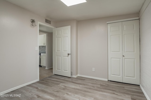 6664 E Mary Dr, Tucson, AZ 85730 - unfurnished bedroom with light wood-type flooring, a closet, and baseboards