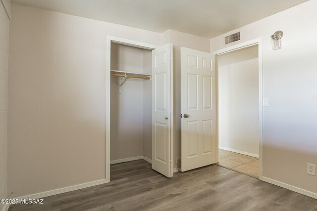 6664 E Mary Dr, Tucson, AZ 85730 - unfurnished bedroom featuring wood finished floors, a closet, and baseboards