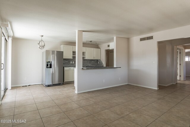 6664 E Mary Dr, Tucson, AZ 85730 - kitchen with stainless steel fridge with ice dispenser, tasteful backsplash, dark countertops, light tile patterned floors, and white cabinetry
