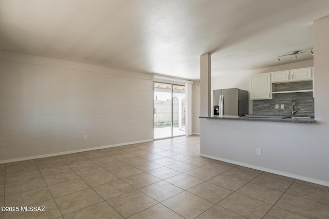6664 E Mary Dr, Tucson, AZ 85730 - unfurnished living room featuring light tile patterned flooring, baseboards, and a sink