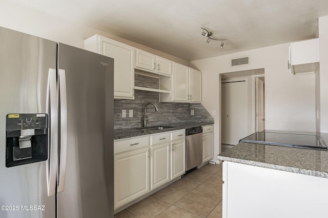 6664 E Mary Dr, Tucson, AZ 85730 - kitchen featuring appliances with stainless steel finishes, a sink, backsplash, light tile patterned floors, and dark stone counters