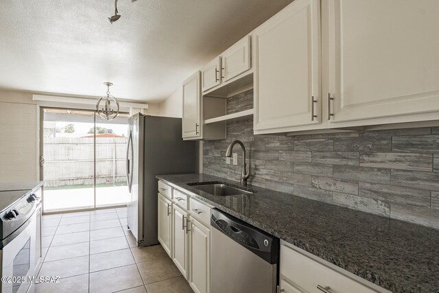 6664 E Mary Dr, Tucson, AZ 85730 - kitchen with stainless steel appliances, a sink, tasteful backsplash, dark stone counters, and a chandelier