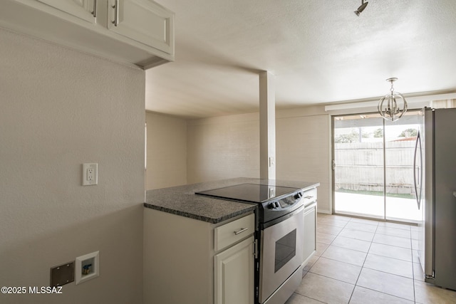 6664 E Mary Dr, Tucson, AZ 85730 - kitchen with stainless steel appliances, a chandelier, light tile patterned floors, decorative light fixtures, and white cabinetry