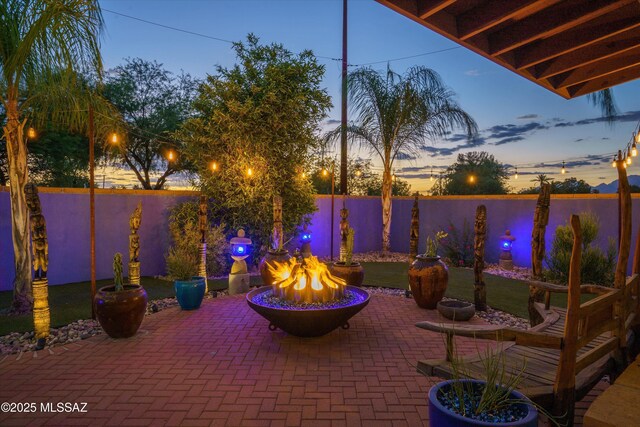 4631 E Bellevue St, Tucson, AZ 85712 - patio terrace at dusk with an outdoor fire pit and a fenced backyard
