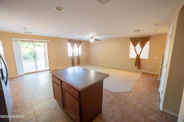 14333 S Camino Vallado, Sahuarita, AZ 85629 - kitchen featuring light tile patterned floors, a center island, ceiling fan, baseboards, and hanging light fixtures