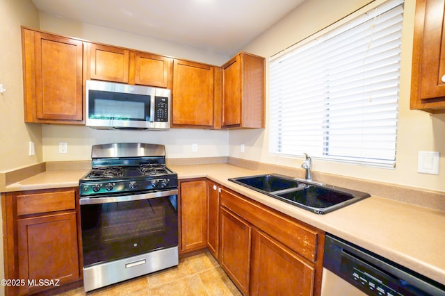 14333 S Camino Vallado, Sahuarita, AZ 85629 - kitchen with stainless steel appliances, a sink, light countertops, and brown cabinets
