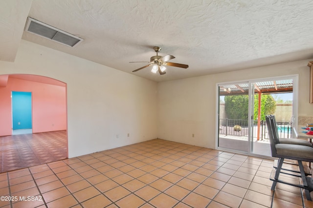 2831 W Puccini Pl, Tucson, AZ 85741 - empty room featuring a ceiling fan, arched walkways, a textured ceiling, and light tile patterned floors