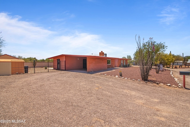 2831 W Puccini Pl, Tucson, AZ 85741 - back of property featuring fence, a chimney, a carport, and dirt driveway