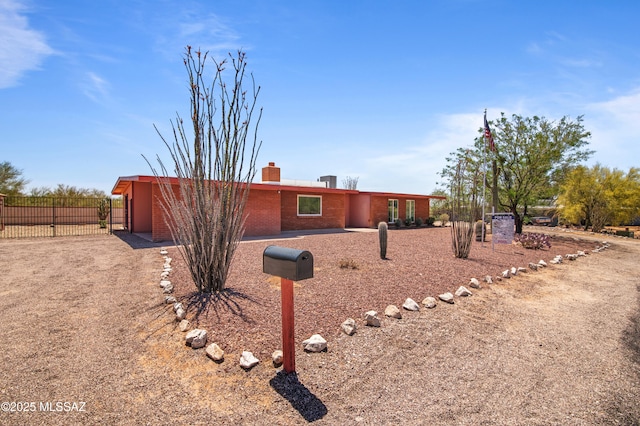 2831 W Puccini Pl, Tucson, AZ 85741 - view of front of house featuring fence, brick siding, and a chimney