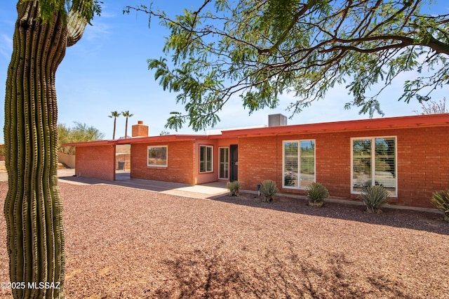 2831 W Puccini Pl, Tucson, AZ 85741 - rear view of house with brick siding, a chimney, and a patio