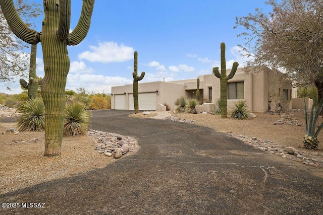 11126 N Guava Dr, Oro Valley, AZ 85737 - pueblo-style home featuring driveway, an attached garage, and stucco siding