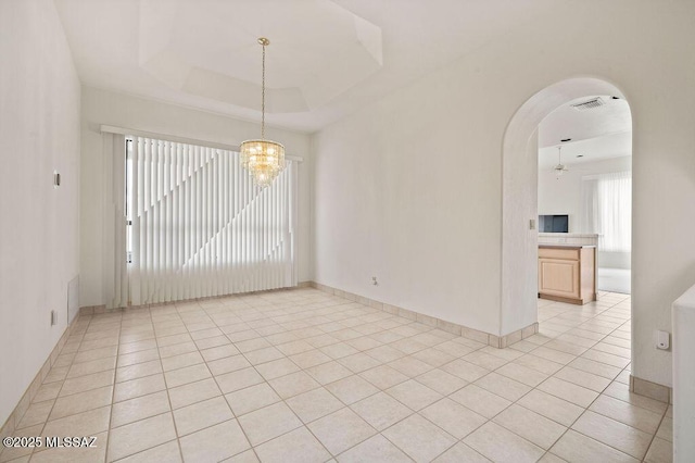 11126 N Guava Dr, Oro Valley, AZ 85737 - empty room featuring a chandelier, arched walkways, baseboards, and light tile patterned floors
