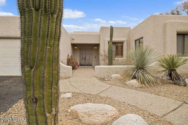 11126 N Guava Dr, Oro Valley, AZ 85737 - view of exterior entry with stucco siding and a garage