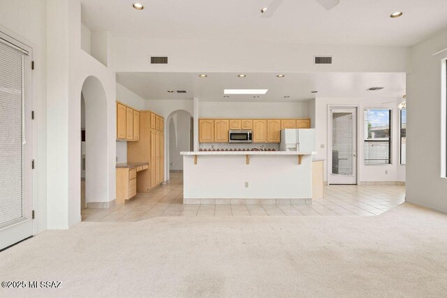 11126 N Guava Dr, Oro Valley, AZ 85737 - unfurnished living room with light colored carpet, arched walkways, light tile patterned floors, recessed lighting, and baseboards