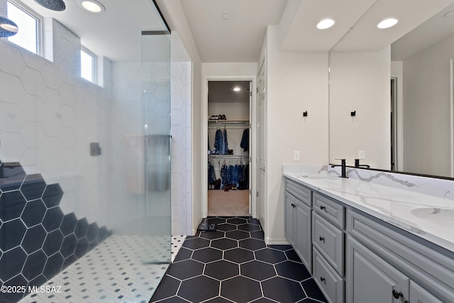 7809 S Land Grant Dr, Tucson, AZ 85747 - bathroom with a walk in shower, double vanity, a walk in closet, recessed lighting, and tile patterned flooring