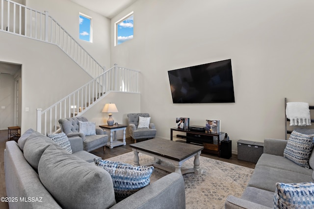 7809 S Land Grant Dr, Tucson, AZ 85747 - living area with stairway, wood finished floors, a towering ceiling, and baseboards