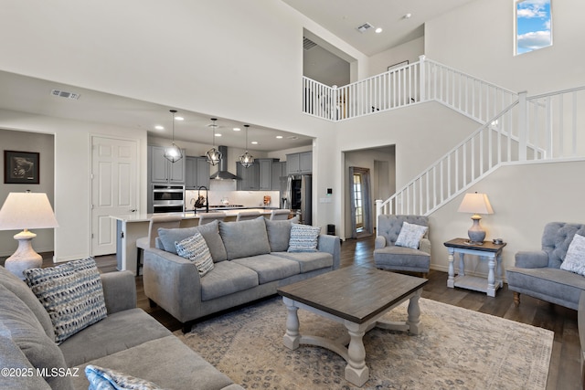 7809 S Land Grant Dr, Tucson, AZ 85747 - living area with stairway, dark wood-style floors, baseboards, a towering ceiling, and recessed lighting