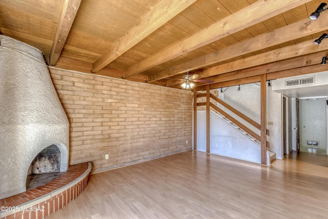 2777 N Treat Ave, Tucson, AZ 85716 - unfurnished living room featuring wood ceiling, beam ceiling, wood finished floors, a ceiling fan, and brick wall