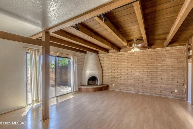 2777 N Treat Ave, Tucson, AZ 85716 - unfurnished living room with a ceiling fan, wood finished floors, beamed ceiling, wooden ceiling, and brick wall