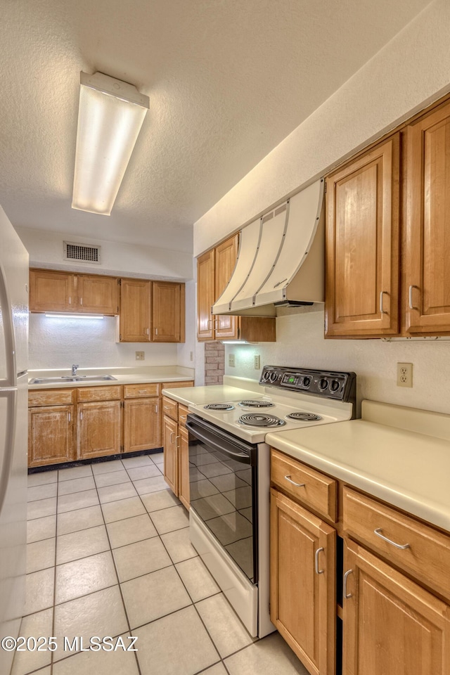 2777 N Treat Ave, Tucson, AZ 85716 - kitchen with white electric range oven, exhaust hood, light countertops, light tile patterned floors, and a textured ceiling