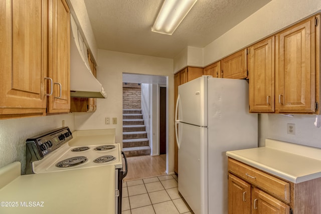 2777 N Treat Ave, Tucson, AZ 85716 - kitchen featuring white appliances, extractor fan, light countertops, light tile patterned floors, and brown cabinets