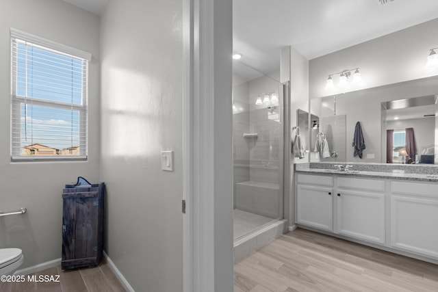 17303 S Nicholas Falls Dr, Vail, AZ 85641 - bathroom with toilet, a stall shower, vanity, wood finished floors, and baseboards