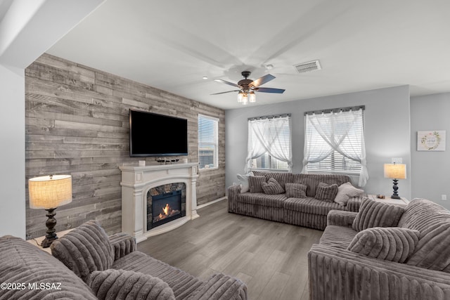 17303 S Nicholas Falls Dr, Vail, AZ 85641 - living area with an accent wall, a ceiling fan, wood finished floors, and a glass covered fireplace