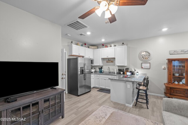 17303 S Nicholas Falls Dr, Vail, AZ 85641 - kitchen with appliances with stainless steel finishes, a peninsula, white cabinets, a breakfast bar, and recessed lighting