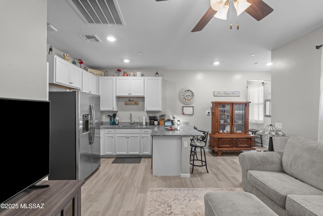 17303 S Nicholas Falls Dr, Vail, AZ 85641 - kitchen with stainless steel refrigerator with ice dispenser, open floor plan, a breakfast bar area, white cabinets, and recessed lighting
