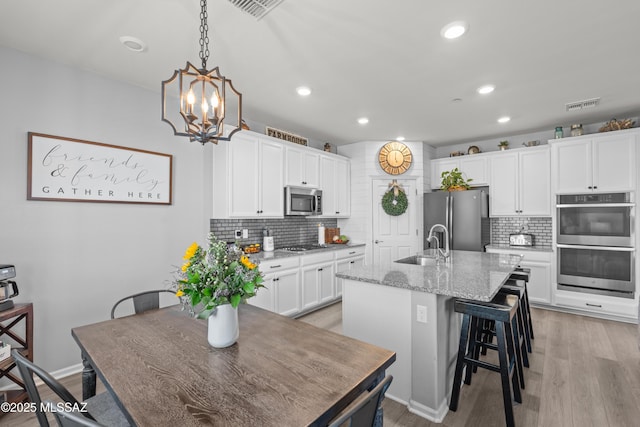 17303 S Nicholas Falls Dr, Vail, AZ 85641 - kitchen with stainless steel appliances, a sink, backsplash, white cabinets, and recessed lighting