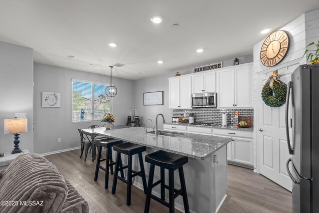 17303 S Nicholas Falls Dr, Vail, AZ 85641 - kitchen featuring appliances with stainless steel finishes, a sink, decorative backsplash, wood finished floors, and recessed lighting