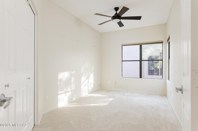 unfurnished room featuring carpet flooring, ceiling fan, and baseboards