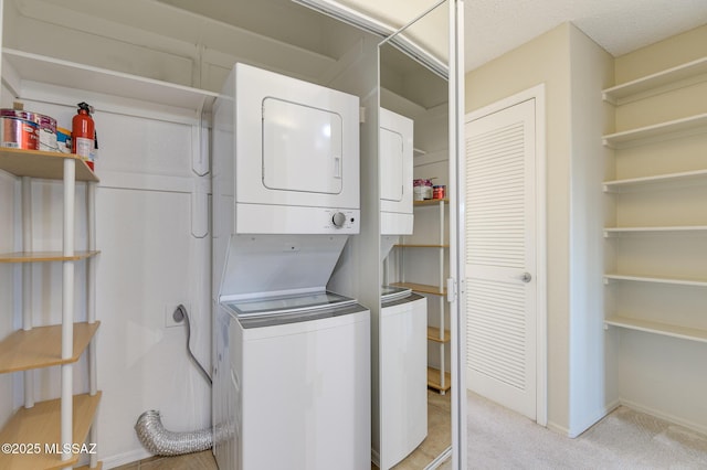 laundry area with stacked washer / drying machine, light carpet, and baseboards