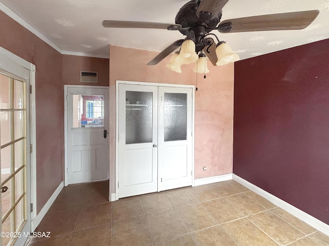 919 W 3rd Ave, San Manuel, AZ 85631 - unfurnished bedroom featuring tile patterned floors, baseboards, a ceiling fan, a closet, and crown molding