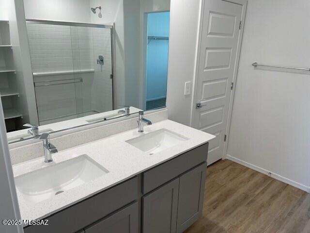 12203 E Patricia Ann Dr, Vail, AZ 85641 - full bathroom featuring a stall shower, wood finished floors, baseboards, double vanity, and a spacious closet