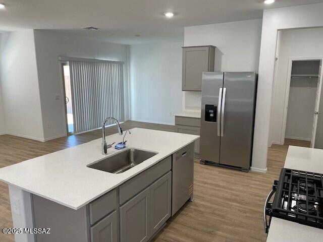 12203 E Patricia Ann Dr, Vail, AZ 85641 - kitchen featuring stainless steel appliances, a sink, gray cabinetry, light wood-type flooring, and light countertops