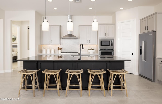 kitchen with stainless steel appliances, a sink, dark countertops, decorative backsplash, and recessed lighting
