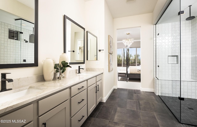 ensuite bathroom featuring a shower stall, double vanity, a chandelier, baseboards, and tile patterned floors