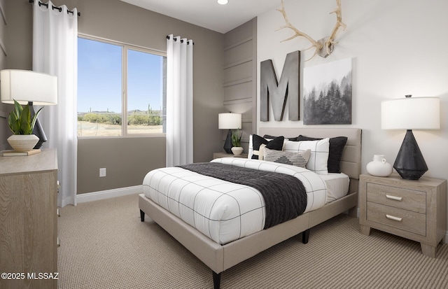bedroom featuring light carpet and baseboards