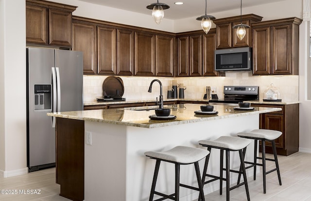 kitchen with stainless steel appliances, decorative backsplash, light stone countertops, a breakfast bar, and recessed lighting