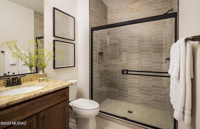 bathroom featuring a shower stall, vanity, and toilet