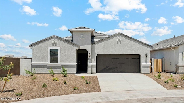 view of front of property with an attached garage, fence, stucco siding, and driveway