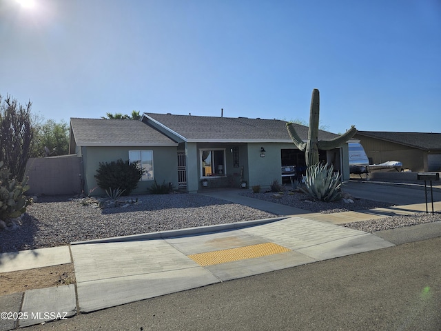 ranch-style house with stucco siding and a shingled roof