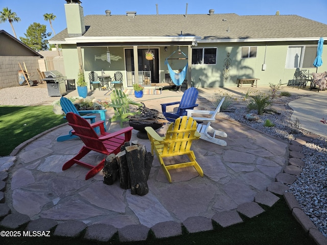back of house featuring a fire pit, a patio area, and a chimney