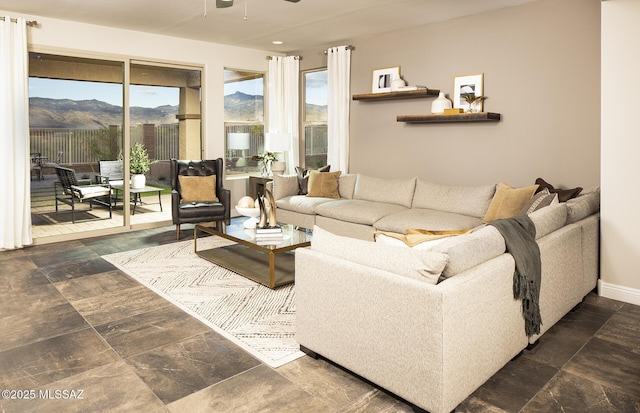 13478 E Silverra Pl, Tucson, AZ 85747 - living room featuring ceiling fan, baseboards, a mountain view, and stone finish floors