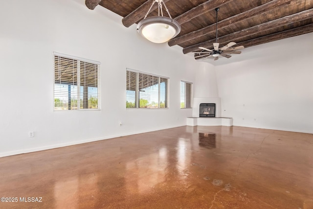 13940 E Hay Bale Trl, Vail, AZ 85641 - unfurnished living room featuring wood ceiling, beamed ceiling, concrete flooring, a large fireplace, and ceiling fan